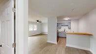 Located at 3735 Trilling Ave, Unit #204 in Rockford, IL, this one-bedroom, one-bathroom residence offers a well-organized and efficiently designed living space. The open-concept layout seamlessly connects the kitchen and living room, creating a bright and airy atmosphere. Light-toned vinyl plank flooring runs throughout the unit, providing a clean and cohesive look.

The kitchen is outfitted with light gray cabinetry featuring matte black hardware, stone-look countertops, stainless steel appliances including a refrigerator, range, and over-the-range microwave, as well as a double basin sink with a matte black faucet. A built-in wood-topped shelf adds a functional accent near the kitchen area.

The living room is spacious and bright, benefiting from a sliding glass door that leads to an outdoor area, allowing for generous natural light and outdoor views. A ceiling fan adds comfort to the space.

The bedroom is comfortably sized, featuring two sets of louvered bi-fold closet doors that provide ample storage, a ceiling fan, and a window that invites natural light. The clean white walls throughout the unit enhance the sense of openness. The bathroom is finished in a crisp, all-white palette. Overall, the unit presents a clean, modern aesthetic with practical features throughout.