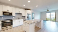 Located in Allen, TX, this well-appointed 3-bedroom, 2-bathroom single-floor residence offers a thoughtfully designed layout with modern finishes throughout. The open-concept kitchen and living area serves as the heart of the home, featuring white shaker cabinets, granite countertops, a subway tile backsplash in a soft blue-gray hue, stainless steel appliances, and a central island ideal for dining or entertaining. Light wood-style flooring flows through the main living areas, complemented by recessed lighting and a ceiling fan.

The spacious living room is filled with natural light, thanks to large sliding glass doors that open onto a private balcony with open views. The primary bedroom is generously sized with plush carpet, a dedicated walk-in closet with built-in shelving, and an en-suite bathroom featuring a dual-sink vanity with granite countertops, white cabinetry with matte black hardware, and LED-backlit mirrors. The secondary bathroom mirrors the same refined aesthetic. Additional bedrooms offer ample closet space with carpet flooring. The residence also includes a pantry, dedicated laundry area, and a hallway connecting all spaces seamlessly for comfortable, everyday living.