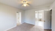 This well-organized 3-bedroom, 1-bathroom unit is thoughtfully arranged across a single floor, offering a practical and functional layout. The space is finished in a neutral, light gray palette throughout, creating a clean and cohesive aesthetic.

The primary bedroom is the most spacious of the three, featuring soft carpeted flooring, a ceiling fan with integrated lighting, and an open doorway that connects to the adjacent living area. A second bedroom benefits from a pair of windows that invite natural light and includes a classic white radiator for heating. The third bedroom similarly features carpet, a ceiling fan, a radiator, and its own window, along with an open closet for storage convenience.

The kitchen is equipped with light wood cabinetry, granite-style countertops, a stainless steel sink, and a black gas range. A window above the radiator brings in natural daylight, and the tile floor adds a practical, easy-to-clean surface.

The bathroom is finished in white with tile flooring, featuring a full bathtub and shower combination, a vanity with sink, and a window for ventilation. An adjacent closet with built-in shelving provides additional storage.

Radiator heating is consistent throughout the unit, and each room maintains a bright, neutral finish, making the space versatile and move-in ready.