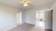 This well-organized 3-bedroom, 1-bathroom unit is thoughtfully arranged across a single floor, offering a practical and functional layout. The space is finished in a neutral, light gray palette throughout, creating a clean and cohesive aesthetic.

The primary bedroom is the most spacious of the three, featuring soft carpeted flooring, a ceiling fan with integrated lighting, and an open doorway that connects to the adjacent living area. A second bedroom benefits from a pair of windows that invite natural light and includes a classic white radiator for heating. The third bedroom similarly features carpet, a ceiling fan, a radiator, and its own window, along with an open closet for storage convenience.

The kitchen is equipped with light wood cabinetry, granite-style countertops, a stainless steel sink, and a black gas range. A window above the radiator brings in natural daylight, and the tile floor adds a practical, easy-to-clean surface.

The bathroom is finished in white with tile flooring, featuring a full bathtub and shower combination, a vanity with sink, and a window for ventilation. An adjacent closet with built-in shelving provides additional storage.

Radiator heating is consistent throughout the unit, and each room maintains a bright, neutral finish, making the space versatile and move-in ready.