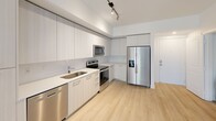 Located in the heart of Boca Raton, FL, this thoughtfully designed one-bedroom, one-bathroom apartment offers a clean, modern aesthetic throughout. Light wood-tone flooring flows seamlessly across every room, creating a bright and cohesive atmosphere.

The kitchen is a standout feature, outfitted with sleek, flat-front cabinetry in a soft white finish that extends floor to ceiling, maximizing storage. Stainless steel appliances — including a French door refrigerator with ice and water dispenser, electric range, over-the-range microwave, and dishwasher — complement the crisp white countertops. Track lighting overhead adds a contemporary touch.

The bedroom is a calm, neutral retreat, bathed in natural light from a large window with views of the surrounding community. Light walls and the warm wood flooring create an inviting, airy feel.

The bathroom is finished with a clean white vanity featuring ample drawer storage, an undermount sink, white countertop, and a large mirror. Directly accessible from the bathroom is a dedicated walk-in closet fitted with multi-tier wire shelving, offering generous organizational space.

A hallway connects the rooms efficiently, with the open layout providing a smooth flow throughout this well-appointed Boca Raton residence.