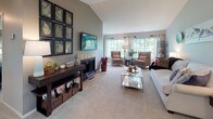 This single-floor residence in Southgate, Michigan, presents a well-organized layout across two bedrooms and one bathroom. The living room serves as a central highlight, featuring vaulted ceilings that lend a sense of openness, plush carpeting, and a tile-surround fireplace positioned as a natural focal point. Large windows line the far wall, inviting generous natural light and views of the surrounding greenery, creating a bright and welcoming atmosphere.

The galley-style kitchen is efficiently designed with white cabinetry, wood-look flooring, granite-style countertops, and a mosaic tile backsplash. Track lighting overhead illuminates the full length of the space, which includes ample storage and a full suite of appliances.

Both bedrooms offer comfortable proportions with carpeted floors. One bedroom features mirrored sliding closet doors that reflect light throughout the room, while the second includes a window framing outdoor greenery. The single bathroom is notably detailed, with a soaking tub, rain showerhead, stone-look tile flooring, and bold horizontal striped walls, with a walk-in closet accessible directly from the bathroom.