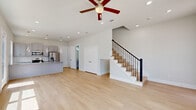 Located in Richmond, TX, this two-story home offers a well-designed layout spread across two floors, with three bedrooms, three full bathrooms, and an attached garage. The ground floor features a bright, open-concept living and kitchen area bathed in natural light from large windows and a glass-panel entry door. The modern kitchen is a standout, boasting granite countertops on a central island, gray shaker-style cabinetry, stainless steel appliances including a gas range, microwave, and French door refrigerator, complemented by elegant spiral pendant lighting and recessed ceiling lights. Light wood-tone flooring flows seamlessly throughout the living spaces. Upstairs, three well-proportioned bedrooms offer views of the surrounding neighborhood, with the spacious primary bedroom providing ample room. Each of the three bathrooms is finished with gray vanity cabinetry, white countertops, and large-format tile in the shower and tub surrounds, paired with wood-tone flooring for a clean, contemporary feel. The attached garage features a modern panel-style door with glass inserts, concrete flooring, and direct interior access. Throughout the home, a neutral color palette and clean architectural lines create a bright, cohesive ambiance.
