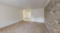 Located at 800 Beatty Rd in Columbia, SC, this one-bedroom, one-bathroom unit offers a well-organized single-floor layout designed for comfortable everyday living. The living room is generously proportioned, featuring soft wall-to-wall carpeting, neutral white walls, a textured ceiling, and an open passage leading into a secondary area equipped with a ceiling fan — creating an airy, connected feel throughout the main living space. A striking exposed brick accent wall adds character and warmth to the living area, serving as a standout architectural detail. The bedroom is a comfortably sized private retreat with plush carpeting, neutral tones, and a double window fitted with blinds that invites natural light and views of the surrounding greenery. The full bathroom is clean and functional, featuring a tub-shower combination, a vanity with a light stone-finish countertop, and wood-look flooring. The kitchen is highlighted by an exposed brick wall and a window with blinds, lending a distinctive, rustic charm alongside light-toned cabinetry and countertops. A connecting hallway ties the rooms together efficiently. The overall ambiance is bright, neutral, and move-in ready, offering a practical and comfortable living environment.