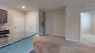 Located at 3340 Shipley St in Ladson, South Carolina, this single-floor residence offers a thoughtfully designed layout with consistent finishes throughout. The kitchen is a standout feature, equipped with rich dark-wood cabinetry, granite countertops, black appliances including a refrigerator, electric range, and microwave, and light wood-style flooring that adds a clean, modern aesthetic. A granite-topped island or breakfast bar connects the kitchen to the adjacent living and dining area, which is finished with soft, neutral-toned carpet and includes a ceiling fan for year-round comfort.

The living space is open and well-proportioned, flowing naturally into the rest of the unit. Multiple bedrooms feature plush carpeting, ceiling fans, and windows with blinds that allow natural light to filter in while providing privacy. The bedrooms offer generous space suitable for a variety of furniture arrangements.

Two full bathrooms serve the unit. One features a granite vanity with a dark wood cabinet base, a tub-shower combo with tiled surround, and wood-style tile flooring. The second bathroom mirrors the same granite vanity and cabinetry style, paired with a walk-in shower. Neutral warm-beige tones are carried throughout the unit, creating a cohesive and inviting atmosphere. A double-door closet provides additional storage in the living area.