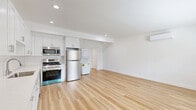 This one-bedroom, one-bathroom unit at 3630 Midvale Avenue in Los Angeles offers a clean, modern aesthetic throughout its efficiently designed single-floor layout. Light-toned hardwood flooring runs continuously across every room, creating a cohesive and airy feel that amplifies the natural light admitted through horizontal slatted windows in both the bedroom and living areas.

The open kitchen and living room share a generous combined footprint, forming the heart of the unit. The kitchen features floor-to-ceiling white shaker cabinetry, white subway tile backsplash, light quartz countertops, and a full suite of stainless steel appliances including a gas range, dishwasher, microwave, and refrigerator. A stacked washer and dryer unit is conveniently integrated into the kitchen area.

The living room is bright and open, with a wall-mounted mini-split system providing individual climate control. The bedroom offers a comfortable, well-proportioned space with its own mini-split unit, a wide window for natural light, and a sliding-door closet.

The bathroom is finished with marble-style tile surrounding a full soaking tub and shower combination, complemented by brushed gold fixtures, a white vanity, and a privacy window. Clean white walls and crisp trim throughout give the entire unit a fresh, move-in-ready appearance.