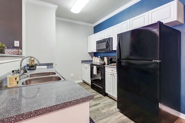 Cocina comedor con electrodomésticos de color negro - Parkways on Prairie Creek