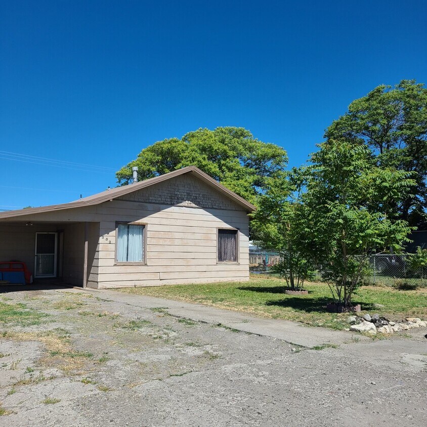 Carport with front door into small foyer - 552 5th Ave W
