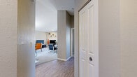 This two-story Breckenridge residence offers a thoughtfully designed layout across two floors. The main level features an open-concept living and dining area bathed in natural light from large windows with blinds. The living room includes a corner fireplace and plush carpeting, creating a warm and inviting atmosphere. Adjacent to the dining area, a sliding glass door leads to an outdoor space, while a pendant light fixture anchors the dining room. The kitchen is well-appointed with dark wood cabinetry, light stone countertops, stainless steel appliances including a range, microwave, and dishwasher, and a double-basin sink beneath a bright window. Wood-look flooring flows through the entryway and kitchen, transitioning to soft carpet in the living areas. Both bathrooms feature wood-look tile flooring, light stone vanity countertops, and dark wood cabinetry, with natural light from windows. The bedrooms are carpeted and restful, with the primary bedroom showcasing dual mirrored sliding closet doors that maximize both storage and the sense of space. A textured ceiling finish is consistent throughout, contributing to the home's cohesive, contemporary aesthetic.