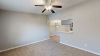 This single-story, two-bedroom, one-bathroom home in Houston's Walnut Bend area offers a well-organized layout designed for comfortable everyday living. The living room serves as the heart of the home, featuring plush carpeting, a ceiling fan with light fixture, and an open sightline to the kitchen via a pass-through counter — ideal for entertaining or casual dining. The adjacent dining area features light wood-look flooring and a flush ceiling light, creating a clean transition between spaces.

The kitchen is efficiently designed in a galley style, with gray cabinetry lining both sides, white countertops, a stainless-style sink, a dishwasher, and a mosaic tile backsplash as a decorative accent. Light wood-look flooring carries through this space, complementing the neutral gray palette.

Both bedrooms are carpeted and generously proportioned, with the primary bedroom offering ample space and a ceiling fan. Each room features soft, neutral wall tones and good natural light from windows with blinds.

The bathroom includes a full tub-shower combo with white tile surround, a toilet, and light flooring. A dedicated closet provides practical storage. Ceiling fans throughout the home add comfort, and the consistent use of neutral tones and clean finishes gives the space a fresh, move-in-ready feel.