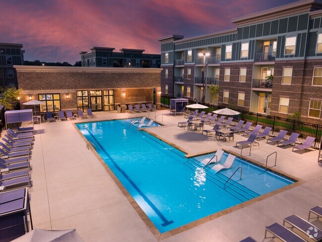 Resort-Style Swimming Pool with Sun Shelf and Fountains at Night - Ardmore at the Trail