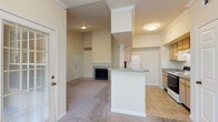 This single-floor residential unit offers a practical and comfortable layout designed for everyday living. The open-concept living and dining area is anchored by a wood-burning fireplace with a tiled surround, creating a welcoming focal point. Soft wall-to-wall carpeting extends throughout the living spaces and bedrooms, while large windows invite natural light and provide views of surrounding greenery.

The galley-style kitchen is efficiently arranged with light wood cabinetry, speckled granite-look countertops, and tile flooring. It comes equipped with a full suite of appliances including an electric range, dishwasher, and refrigerator, and features a pass-through breakfast bar that connects seamlessly to the living area.

The bedrooms are generously proportioned, each outfitted with ceiling fans, carpeted floors, and windows overlooking outdoor greenery. Closet access is conveniently located within each room.

The bathrooms are finished with tile flooring and feature a full tub-and-shower combination with white tile surround in one bath, and a vanity with speckled countertop, wood cabinetry, and a well-lit mirror in another. Crown molding details and consistent neutral tones throughout the unit contribute to a cohesive and clean aesthetic.