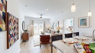 This thoughtfully designed single-story residence offers three bedrooms, two bathrooms, and three closets within a cohesive, efficiently laid-out floor plan. Light wood-tone flooring flows consistently throughout, lending warmth and visual continuity to the entire space.

The open-concept living and dining area serves as the heart of the home, featuring a ceiling fan, recessed lighting, and French doors that invite natural light and outdoor views. The living room is highlighted by neutral tones, a decorative round mirror, and wall art that adds character to the bright, airy atmosphere.

The kitchen is well-equipped with white shaker cabinetry, granite-style countertops, stainless steel appliances, and a galley-style layout that maximizes functionality. A hallway connects the kitchen to the bedroom wing, maintaining an organized flow throughout.

The primary bedroom offers a comfortable, private retreat with a window for natural light. The additional bedrooms are similarly well-proportioned, each with light walls and room for furnishings. Three dedicated closets provide practical storage throughout the unit.

The two bathrooms are finished with clean white fixtures and granite countertops. The primary bathroom features a glass-enclosed shower, while the secondary bathroom includes a full tub-shower combination — both finished with light wood flooring for a consistent, polished look.