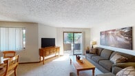 Located at 693 Meadow Wood Dr in Crescent Springs, Kentucky, this single-floor residence offers a thoughtfully arranged layout with comfortable living spaces throughout. The living room serves as the heart of the home, featuring plush carpeting, a textured ceiling, and a sliding glass door that opens to a private balcony, flooding the space with natural light and providing outdoor views of surrounding greenery. The room offers ample space for seating and entertainment.

Adjacent to the living area, the dining space is highlighted by a pendant light fixture overhead and a window with vertical blinds, creating a bright and welcoming atmosphere. Warm pine furnishings add a consistent, natural aesthetic throughout.

The kitchen is well-appointed with rich wooden cabinetry, light countertops, and a full suite of appliances including a range, dishwasher, and refrigerator. A textured backsplash and ceiling light complete the functional yet charming cooking space.

The bedroom is a serene retreat, featuring carpeted floors, natural light from a window, and room for a full dresser and seating area. The full bathroom includes a tub-shower combination with clean, neutral finishes.

Throughout the residence, a cohesive warm and neutral color palette, consistent wood tones, and carpeted floors contribute to a cozy and inviting overall ambiance.