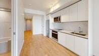 Located at 707 Terry Ave in Seattle's vibrant First Hill neighborhood, this thoughtfully designed unit offers a clean, contemporary aesthetic throughout its single-floor layout. The interior is defined by light hardwood flooring, crisp white walls, and recessed lighting that create a bright and airy atmosphere.

The open living area connects seamlessly to a modern kitchen outfitted with white flat-panel cabinetry extending to the ceiling, stainless steel appliances including a refrigerator, oven, microwave, and a cooktop with a marble-style backsplash. Track lighting illuminates the kitchen, enhancing its functional yet stylish design.

Floor-to-ceiling sliding glass doors in the living area frame sweeping views of the Seattle skyline and surrounding cityscape, flooding the space with natural light and providing a striking visual connection to the urban environment outside.

A clean, well-proportioned hallway — lined with recessed lighting and flush-panel storage — guides residents through the unit. The bathroom features a floating white vanity with a vessel sink, a large wall mirror, a combined soaking tub and shower with a handheld fixture, and terrazzo-style flooring in neutral tones, offering a polished, spa-like finish. The overall design prioritizes minimalism, functionality, and modern urban living.