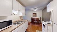 Located in Brooklyn Park, Minnesota, this one-bedroom, one-bathroom unit offers a practical and comfortable single-floor layout. The living room is a welcoming space featuring plush carpet flooring, a textured ceiling, and a large sliding glass door with vertical blinds that floods the room with natural light and provides a pleasant outdoor view. The open flow connects the living area to the dining space and kitchen, where white cabinetry, a double-basin sink, laminate countertops, and hardwood-style flooring create a clean, functional environment. A ceiling fan overhead in the dining area adds comfort to the space.

The bedroom is a well-proportioned retreat with soft carpet, a ceiling fan with light fixture, a window with vertical blinds, and a sliding closet. The unit includes three closets in total, providing ample storage throughout. A carpeted hallway connects the bedroom to the full bathroom, which features tile flooring, a white vanity with sink, an overhead storage cabinet, and a shower-tub combination.

The textured ceilings are consistent throughout the unit, and the neutral color palette creates a cohesive and understated aesthetic. This unit offers a functional layout well-suited for comfortable everyday living.