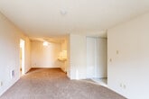 Located at 2300 Fairview Rd in Costa Mesa, California, this single-floor unit offers a practical and functional layout throughout. The main living area is finished with wall-to-wall carpeting, textured ceilings, and warm neutral tones that create a comfortable atmosphere. A ceiling fan provides additional ventilation, while a sliding glass door floods the space with natural light and opens to an outdoor area with views of surrounding greenery. A wall-mounted air conditioning unit ensures year-round comfort. The kitchen is efficiently designed with light wood-style flooring, tile countertops, white cabinetry, a built-in cooktop, a dishwasher, and a sink — all arranged to maximize counter and storage space. A pass-through counter connects the kitchen to the adjacent dining or living area, enhancing the open feel. Closet storage is provided via sliding panel doors with vertical wood detailing. The bathroom features a wide vanity with a single basin sink, tile-toned countertops, white cabinetry, a large mirror with Hollywood-style lighting above, and a combined tub and shower. Wood-style flooring in the bathroom adds a warm, cohesive finish. The entry door opens to a tiled foyer that transitions into the main carpeted living space, providing a clean delineation between areas.
