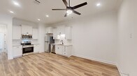 Located at 101 Barnes Ln in Broussard, Louisiana, this well-appointed 2-bedroom, 2-bathroom single-story home offers a thoughtfully designed layout with modern finishes throughout. The open-concept kitchen and living area serves as the heart of the home, featuring crisp white shaker cabinetry, a subway tile backsplash, stainless steel appliances including a refrigerator and dishwasher, and a sleek single-basin sink. Light wood-look flooring flows seamlessly throughout the space, complemented by recessed lighting and a ceiling fan that enhances both comfort and ambiance. Connecting hallways lead to the two bedrooms, each finished with the same consistent flooring, clean white walls, and ceiling fans. The primary bedroom includes a closet and a window that brings in natural light. Both bathrooms are well-finished with white cabinetry, granite-style countertops, and glass-enclosed walk-in showers clad in large-format marble-look tile with black hardware accents. A dedicated laundry room provides added convenience, complete with a full-size washer and dryer and overhead cabinetry for storage. The overall design is cohesive and modern, emphasizing clean lines, neutral tones, and functional living throughout.