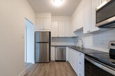 Located at 1176 Whitefield Dr in Peterborough, Ontario, this well-appointed 1-bedroom, 1-bathroom unit offers a clean, modern aesthetic throughout. Light-toned laminate flooring runs continuously across the space, complementing the crisp white walls and creating a bright, cohesive feel.

The open-concept living and dining area is the heart of the unit, bathed in natural light from a large sliding glass door that leads directly to a private balcony. The balcony offers elevated views of the surrounding Peterborough neighbourhood, adding a sense of openness to the space.

The kitchen is thoughtfully designed with white shaker-style cabinetry, a subway tile backsplash, stainless steel appliances including a range and over-the-range microwave, and a single-basin sink. It connects seamlessly to the living and dining area through an open passageway.

The bedroom is a well-proportioned, quiet retreat with clean white walls and the same warm laminate flooring. The bathroom features a full soaker tub and shower combination with classic white subway tile surround and chrome fixtures, lending a timeless, clean look. A hallway connects the key areas of the unit, completing this functional and attractively finished home.
