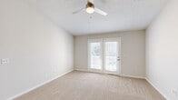 Located at 305 Brookfield Dr in Myrtle Beach, SC, this two-bedroom, two-bathroom single-story home offers a well-organized and functional layout. The living room serves as the heart of the home, featuring soft carpeting, a ceiling fan with light fixture, and a set of French doors fitted with slatted blinds that invite natural light and provide outdoor access. The space transitions seamlessly into the kitchen, where light wood-style flooring continues throughout. The galley-style kitchen is efficiently designed with ample white cabinetry, dark granite-style countertops, a stainless steel double-basin sink, and a full suite of stainless steel appliances including a refrigerator, electric range, microwave, and dishwasher. Both bedrooms are carpeted and finished with neutral tones. The primary bedroom is generously sized and includes a walk-in closet outfitted with wire shelving and hanging rods on multiple walls. Each bathroom features a clean, all-white tub and shower combination with chrome fixtures. A dedicated utility room and additional closet storage add to the home's practical appeal. Throughout, the neutral color palette, clean lines, and consistent finishes create a bright and cohesive living environment.