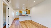 Located on Traverse Drive in Bellingham, Washington, this modern two-story home offers 2 bedrooms and 3 bathrooms across two well-appointed floors. The main level features an open-concept kitchen and living area finished with warm, light-toned hardwood flooring throughout. The kitchen is a standout, boasting a large white quartz peninsula with an undermount sink and matte black faucet, warm wood cabinetry, stainless steel appliances, and stylish pendant lighting. Recessed lighting and windows facing the front entry fill the space with natural light. A hallway on the main level leads to a clean, minimalist half bathroom with a wood-toned vanity and white countertop. Upstairs, the two bedrooms are carpeted and bright, each featuring windows with neighborhood views. The primary bedroom offers a comfortable footprint, while the second bedroom is equally well-lit. Three bathrooms serve the home, including one with a full soaking tub and shower combo fitted with matte black fixtures. The staircase connects both levels efficiently. Throughout, the design palette is crisp and contemporary — white walls, black hardware accents, and natural wood tones create a cohesive, clean aesthetic ideal for modern living.