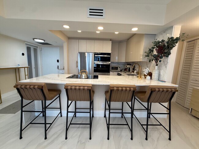 Isla de cocina con tomas de corriente retráctiles. - 500 Three Islands Blvd
