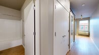Located at 3029 22nd Ave S in Minneapolis, MN, this one-bedroom, one-bathroom unit offers a thoughtfully designed layout that maximizes every square foot. The open-concept kitchen and living area serves as the heart of the home, featuring warm hardwood-style flooring, track lighting, and a well-appointed kitchen with rich dark wood cabinetry, stainless steel appliances including a refrigerator, electric range, and microwave. A sliding barn-style door adds a modern architectural touch to the space. The living area opens to a private balcony through a sliding glass door, offering views of the surrounding Minneapolis neighborhood and allowing natural light to fill the room. The bedroom is a cozy, carpet-floored retreat complete with a double-door closet for ample storage. The bathroom features a full tub/shower combo with clean white surrounds, wood-style flooring, and neutral gray walls. A dedicated hallway with multiple white panel doors provides organized access to the closet, laundry, and bathroom. In-unit laundry adds everyday convenience. The unit's clean, contemporary aesthetic, efficient use of space, and practical amenities make it a functional and comfortable urban residence.
