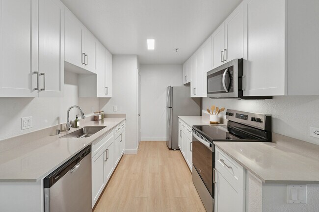 Paquete I de cocina renovada con gabinetes blancos, encimeras de cuarzo gris, electrodomésticos de acero inoxidable y pisos de superficie dura. - Avalon Mountain View