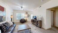 This well-organized single-story residence features three bedrooms, two bathrooms, and a thoughtfully designed floor plan that maximizes functionality and comfort. The open living room is a welcoming centerpiece, featuring plush carpeting, vaulted ceilings, ceiling fans, and large windows that invite natural light and outdoor views. The space comfortably accommodates a seating area and entertainment setup, creating a versatile gathering space.

The kitchen is outfitted with white cabinetry, a full-size refrigerator, dishwasher, and generous counter space, with tile flooring that complements the neutral color palette throughout. It flows naturally into the living area, supporting an open and connected feel.

The primary bedroom is a well-proportioned retreat with carpet flooring, a ceiling fan, natural light from a window, and direct access to a closet. The additional bedrooms are similarly appointed, each featuring carpet, ceiling fans, and windows. Both bathrooms are identically configured with tub-shower combos featuring sliding glass doors, tile flooring, white vanities, and overhead cabinet storage. Two hallways and two closets provide practical storage and circulation throughout the home. The overall ambiance is bright, neutral, and move-in ready.