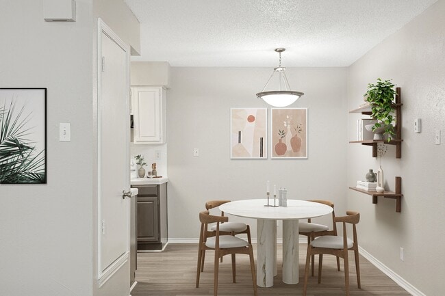 A dining room with modern furniture and art is shown next to kitchen. - ReNew Holiday Hill®