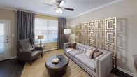 This single-floor residence at 3850 Sycamore School Rd in Fort Worth, Texas, offers a well-appointed layout designed for comfortable everyday living. The open-concept living and dining area serves as the heart of the home, featuring crown molding, a ceiling fan, and warm neutral tones throughout. A striking gold geometric wall panel anchors the living space, adding a bold decorative element alongside large windows dressed with layered curtains and blinds that allow natural light to fill the room.

The kitchen is equipped with stainless steel appliances, including a refrigerator, range, and microwave, complemented by white cabinetry, a subway tile backsplash, granite-style countertops, pendant lighting, and dark hardwood-style flooring. A dedicated dining area sits adjacent to the kitchen, creating a seamless flow between spaces.

The bedrooms offer a calm retreat, each featuring ceiling fans, plush carpeting, and windows with natural light. One room functions as a flexible secondary space, ideal as a sitting room or home office.

The primary bathroom includes a granite-topped vanity and direct access to an in-unit laundry closet with a full-size washer and dryer. A secondary bathroom features a tub-shower combination with tiled surround. The overall ambiance is modern and inviting throughout.