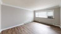 Located at 4925 Fairview Ave in Downers Grove, IL, this single-floor unit offers three bedrooms and one bathroom within a compact, efficiently arranged footprint. The layout is designed to maximize functionality, with wood-style flooring and neutral-toned walls running consistently throughout, creating a cohesive and clean aesthetic.

The spacious primary bedroom is a standout feature, accommodating generous furnishing arrangements and including a well-organized built-in closet system with dual hanging rods and a central shelving tower for ample storage. Additional bedrooms are finished with the same warm flooring, crown molding, and ceiling fans, lending a polished feel throughout.

The kitchen is outfitted with white cabinetry, dark countertops, and a stainless steel refrigerator, flowing naturally into the main living area. Baseboard heaters run beneath windows in the living spaces, providing efficient climate control. Natural light filters in through windows fitted with vertical blinds.

The bathroom is neatly finished with white subway tile surrounding a tub-shower combo, accented by a decorative tile border. Marble-look floor tile, a white vanity with brushed nickel fixtures, and recessed lighting complete the clean, bright space.