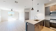 Located in Flagstaff, AZ, this well-designed 2-bedroom, 2-bathroom residence offers a thoughtful layout with modern finishes throughout. The open-concept kitchen and living area serves as the heart of the home, anchored by a sleek kitchen island with a built-in sink and light quartz countertops. The kitchen is outfitted with two-tone cabinetry combining grey and natural wood tones, a white subway tile backsplash, stainless steel appliances including a gas range, microwave, dishwasher, and French door refrigerator, and stylish pendant lighting overhead. Light wood-look flooring extends across the main living areas, complemented by large windows and ceiling fans that create a bright, airy atmosphere. The living room receives abundant natural light and connects seamlessly to the rest of the home. Both bedrooms feature soft carpeting and windows with outdoor views of the surrounding area. The primary bedroom includes a dedicated walk-in closet with built-in shelving and hanging rods. The bathrooms are finished with warm wood vanities, dual sinks, quartz countertops, and bold teal accent walls that add a pop of color. Two closets provide ample storage throughout. The overall aesthetic is clean, contemporary, and move-in ready.