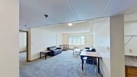 Located at 646 East College Avenue in State College, PA, Unit 3-301 is a third-floor, one-bedroom, one-bathroom apartment spanning 690 square feet of well-organized living space. The open living room features carpeted flooring, a large picture window with vertical blinds that allows ample natural light and outdoor views, and a wall-mounted HVAC unit for climate control. The living area flows seamlessly toward the dining space and kitchen. The kitchen is equipped with wood-toned cabinetry, granite-style countertops, hardwood-style flooring, black appliances including an electric range, dishwasher, and refrigerator, as well as a built-in microwave and overhead ventilation hood. A skylight panel provides additional brightness to the kitchen. The spacious bedroom measures 220 square feet, features carpeted flooring, a window with natural light, and direct access to a generously sized walk-in closet outfitted with dual wire shelving racks for organized storage. The full bathroom includes a standard tub/shower combination with a chrome curtain rod and wood-framed accents. Throughout the unit, neutral wall tones and practical finishes create a clean, functional living environment well-suited for student or single-occupant living.