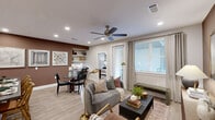 Located at 5026 Zion Rd in Garland, TX, this single-story 2-bedroom, 2-bathroom home offers a thoughtfully designed open-concept floor plan. Light wood-look flooring flows throughout the main living areas, complemented by recessed lighting and ceiling fans. The living room is warm and inviting, anchored by a bold accent wall and large windows that allow abundant natural light to fill the space.

The kitchen is a functional centerpiece, featuring a large island with dark quartz countertops, white shaker cabinetry with matte black hardware, stainless steel appliances, and a subway tile backsplash. It opens seamlessly into the dining area and living room, making it ideal for entertaining. A built-in desk nook with open shelving and matching cabinetry provides a convenient workspace off the main living area.

The primary bedroom offers a comfortable retreat with plush carpet, a ceiling fan, and windows with blinds and drape panels. The en-suite primary bathroom includes a dual-sink vanity with dark countertops, white cabinetry, a walk-in glass shower, and wood-look flooring. The second bedroom is equally well-sized and similarly finished.

Additional features include two closets, an in-unit laundry area, and a second full bathroom. The home's cohesive design palette of warm neutrals and modern fixtures creates a polished, contemporary ambiance throughout.