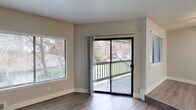 This single-floor residence offers a thoughtfully designed layout with a cohesive, neutral color palette and a mix of hard surface and carpeted flooring throughout. The spacious living room is a standout, featuring a corner fireplace, wood-look flooring, and a large window that fills the space with natural light. Adjacent to the living area is a stepped-down dining nook with a ceiling fan, a built-in countertop with a sink, and direct access to a private outdoor deck through a sliding glass door — ideal for seamless indoor-outdoor living.

The kitchen is efficiently designed with white cabinetry, light countertops, and stainless steel appliances including a refrigerator and electric range. The bedrooms are generously sized, featuring plush carpeting, neutral walls, and windows that bring in natural light. The bathrooms are clean and functional, with wood-look flooring, white cabinetry, light countertops, and brushed nickel fixtures. The full bathroom includes a tub-shower combination, while a second bathroom provides additional convenience. Throughout the space, clean white trim and warm neutral tones create a consistent, move-in-ready atmosphere.