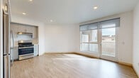 Located at 8811 Sepulveda Blvd in Los Angeles, this 2-bedroom, 1-bathroom unit offers a clean, modern design with a well-planned single-floor layout. Light wood-style flooring runs throughout the entire space, creating a cohesive and bright atmosphere. The open living and dining area is bathed in natural light, courtesy of large floor-to-ceiling windows and a glass door that opens to an outdoor area, offering views of the surrounding neighborhood. Recessed lighting complements the natural light throughout.

The kitchen is efficiently designed with a crisp L-shaped layout, featuring gray cabinetry, white countertops, a stainless steel gas range, dishwasher, and a built-in sink — providing a functional and stylish cooking space that flows seamlessly into the living area.

Both bedrooms are bright and well-proportioned, each featuring light-filled windows with roller shades, light wood flooring, and dedicated closet space. Three closets in total offer ample storage throughout the unit. The bathroom is finished in a clean, minimalist style with a white vanity, large mirror, and matching wood-tone flooring. A hallway connects the rooms, contributing to the efficient and practical flow of the layout.