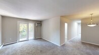 This two-bedroom, one-bathroom unit at 2616 Philadelphia Pike in Claymont, Delaware offers a well-organized single-floor layout with a clean, neutral aesthetic throughout. The living room is generously sized, featuring plush carpeting, a wall-mounted air conditioning unit, and a sliding glass door that opens to a private balcony with outdoor views — filling the space with natural light. Baseboard heating runs throughout the unit, providing efficient climate control.

The kitchen has been thoughtfully updated with two-tone cabinetry — white upper cabinets and slate-blue lower cabinets — complemented by marble-style countertops and a mosaic tile backsplash. Stainless steel appliances, including a refrigerator and electric range, complete the functional cooking space. Light wood-look flooring adds warmth, and a window above the sink brings in natural light.

Both bedrooms are carpeted and feature sliding-door closets, offering practical storage. The primary bedroom is comfortably sized with a window and a wall-unit air conditioner. The second bedroom is bright and well-proportioned with its own natural light source. The bathroom is clean and simple, featuring a tiled tub-shower combination. A washer unit is also conveniently located within the unit.