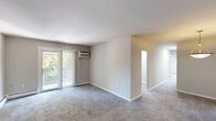 This two-bedroom, one-bathroom unit at 2616 Philadelphia Pike in Claymont, Delaware offers a well-organized single-floor layout with a clean, neutral aesthetic throughout. The living room is generously sized, featuring plush carpeting, a wall-mounted air conditioning unit, and a sliding glass door that opens to a private balcony with outdoor views — filling the space with natural light. Baseboard heating runs throughout the unit, providing efficient climate control.

The kitchen has been thoughtfully updated with two-tone cabinetry — white upper cabinets and slate-blue lower cabinets — complemented by marble-style countertops and a mosaic tile backsplash. Stainless steel appliances, including a refrigerator and electric range, complete the functional cooking space. Light wood-look flooring adds warmth, and a window above the sink brings in natural light.

Both bedrooms are carpeted and feature sliding-door closets, offering practical storage. The primary bedroom is comfortably sized with a window and a wall-unit air conditioner. The second bedroom is bright and well-proportioned with its own natural light source. The bathroom is clean and simple, featuring a tiled tub-shower combination. A washer unit is also conveniently located within the unit.