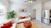 Located at 3040 W Washington St in Stephenville, Texas, this thoughtfully designed one-bedroom, one-bathroom unit maximizes every square foot with a smart, open-concept floor plan. The combined living, dining, and kitchen area forms the heart of the unit, featuring light-toned wood-look flooring, bright white walls, and a ceiling fan with overhead lighting. The living space offers generous natural light through a window, creating an airy and welcoming atmosphere. The kitchen is well-appointed with gray shaker-style cabinetry, dark granite countertops, a double-basin stainless steel sink, and a full suite of stainless steel appliances including a French door refrigerator, electric range, and over-the-range microwave. A dedicated pantry provides additional storage. The bedroom includes a closet with double doors, a window with exterior views, a ceiling fan, and easy access to the adjoining spaces. The bathroom features wood-look tile flooring, a gray vanity with dark granite countertop, and a tub-shower combination. A dedicated laundry area adds everyday convenience. The unit's clean, neutral palette and modern finishes give it a polished, move-in-ready feel suited to comfortable single-level living.