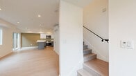 Located in the desirable Mid-City neighborhood of Los Angeles, this modern two-story home offers a thoughtfully designed layout spread evenly across two floors. Light wood flooring runs throughout, creating a bright and cohesive aesthetic complemented by recessed lighting and a clean, contemporary palette of white and warm neutral tones.

The main floor features an open-concept kitchen and living area. The kitchen is well-appointed with stainless steel appliances, a large center island with a quartz countertop, two-tone cabinetry in white and gray, and ample storage. A staircase with a sleek black metal railing connects to the upper level.

Upstairs, two bedrooms provide comfortable retreats, each equipped with wall-mounted mini-split HVAC units for individual climate control. The primary bedroom features mirrored sliding closet doors, while the second bedroom includes a walk-in closet and a vibrant blue accent wall with windows offering views of surrounding palm trees. Both bathrooms are finished with white subway tile tub surrounds, modern vanities with dark wood countertops, and tile flooring.

A hallway connects the upper-floor rooms, and recessed lighting throughout maintains a bright, airy atmosphere. The home's efficient use of space and modern finishes make it a polished urban residence in Los Angeles.