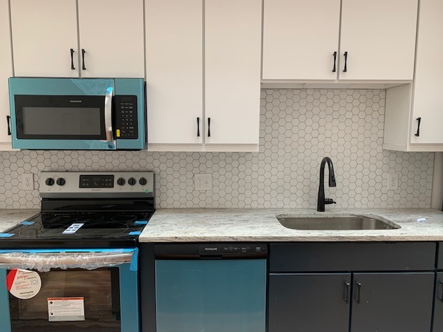 View of kitchen space. Please note that the unit is under construction. Appliances are stainless. - 210 E Grace St