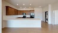 Located at 1335 West Summit Parkway in Spokane, Washington, this single-floor unit offers a thoughtfully designed layout with contemporary finishes throughout. The open-concept living area features light hardwood-style flooring, recessed lighting, and a wall-mounted mini-split system for efficient climate control. Large floor-to-ceiling windows flood the space with natural light and frame sweeping views of the Spokane skyline and surrounding treetops, with access to an outdoor balcony. The kitchen is a standout feature, showcasing rich walnut-toned cabinetry, crisp white countertops, a generous island with an integrated sink, black appliances, and ample storage with both upper and lower cabinetry. Recessed lighting highlights the clean lines of the space. The bedrooms are carpeted for comfort, with large windows that invite natural light and offer neighborhood views. The primary bathroom is equipped with a wood-toned vanity, light countertops, a large mirror, and a walk-in glass-enclosed shower with light tile surround. A second full bathroom features a matching vanity and a shower-tub combination. The unit's neutral color palette, modern fixtures, and cohesive design create a clean, contemporary ambiance throughout.