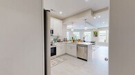 Located at 69 E Central St in Natick, MA, this well-appointed 2-bedroom, 2-bathroom residence offers a thoughtfully designed single-floor layout. The open-concept kitchen and living area serves as the heart of the home, featuring a sleek white shaker-style kitchen with stainless steel appliances, subway tile backsplash, pendant lighting, and ample cabinetry. Light wood-style flooring flows throughout the main living areas, enhancing the bright, airy atmosphere. The living room is a standout, boasting a curved bay of oversized windows that flood the space with natural light and frame sweeping views of downtown Natick. Both bathrooms are finished with crisp white cabinetry, tile flooring, and modern fixtures; one includes a glass-enclosed walk-in shower. The generously sized primary bedroom offers a tranquil retreat with carpeted flooring and recessed lighting, while the second bedroom features large windows with neighborhood views. A dedicated office and closet provide additional functionality. Warm neutral tones and recessed lighting throughout create a cohesive, modern ambiance that is both inviting and practical.