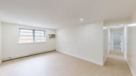 Located at 921 Tyson Ave in Philadelphia's 19111 neighborhood, this 2-bedroom, 1-bathroom unit offers a well-designed, single-floor layout that makes efficient use of its space. The interior is finished with light-toned wood flooring throughout, complementing the crisp white walls and recessed lighting that give the unit a clean, modern feel.

The living room is bright and open, featuring a window unit air conditioner, baseboard heating, and natural light from street-facing windows. The kitchen is thoughtfully appointed with warm-toned wood cabinetry, a white subway tile backsplash, light countertops, and a full suite of stainless steel appliances including a gas range, built-in microwave, and refrigerator.

The primary bedroom is generously sized, benefiting from two windows that allow ample natural light and neighborhood views, along with baseboard heating and a wall-mounted air conditioning unit. The second bedroom includes a built-in closet with double doors, providing convenient storage. In total, the unit offers four closets, ensuring abundant storage throughout.

The bathroom features a full tub-shower combination with large-format white tile surround, matte black fixtures, and a wood-accented vanity. The overall ambiance is clean, minimalist, and move-in ready.