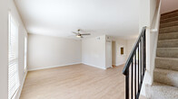 This two-story home offers six bedrooms and two bathrooms spread across two well-proportioned floors, providing ample space for large households or shared living arrangements. The main level features a bright, open living room with light wood laminate flooring, neutral-toned walls, and a ceiling fan that promotes air circulation throughout the space. Adjacent to the living room, the dining area benefits from abundant natural light streaming through large windows and a glass door that opens to the outdoors, complemented by a pendant light fixture overhead. A chair rail detail adds a subtle architectural touch to the dining room walls. The kitchen is thoughtfully designed with white shaker-style cabinetry, marble-look countertops, a subway tile backsplash, stainless steel appliances including a dishwasher, and a window above the sink for natural light. The bathrooms feature marble-look vanity surfaces and clean, neutral finishes. Upstairs, the six bedrooms are carpeted for comfort and each includes a built-in closet with sliding panel doors. The primary bedroom offers a ceiling fan and a window with natural light. A staircase with a dark wood railing connects both floors, and three hallways ensure smooth circulation throughout the home. The overall aesthetic is clean, bright, and move-in ready.