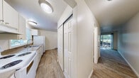 Located in Lynnwood, Washington, this two-bedroom, two-bathroom home is spread across two floors, offering a practical and comfortable layout. The main level houses the kitchen and living room, both featuring wood-look hard surface flooring. The kitchen is well-appointed with white cabinetry, a full suite of white appliances including a range, dishwasher, and refrigerator, along with a window that brings in natural light and views of the surrounding greenery. The living room is bright and inviting, highlighted by a sliding glass door that opens to the outdoors, allowing sunlight to pour in and providing easy access to the exterior. Baseboard heating is present throughout the home for efficient climate control. The upper level hosts both bedrooms, each carpeted and featuring closet storage. The primary bedroom is generously sized with a large sliding-door closet and a window with views of the surrounding trees. The second bedroom also offers natural light through its window and comfortable proportions. Both bathrooms are clean and functional, with one featuring a tiled tub-shower combination, wood-look flooring, and a vanity with storage. Staircases connect the two levels, completing this well-organized two-story home.