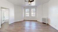 Located at 2505 W 6th St in Los Angeles, this well-appointed one-bedroom, two-bathroom unit offers a thoughtfully designed layout across a single floor. The entrance leads into a bright, open living space highlighted by warm hardwood-style flooring, crisp white walls, and a ceiling fan that keeps the room comfortable year-round. A classic white radiator adds a touch of vintage character, while dual windows invite generous natural light and views of the surrounding neighborhood.

The combined dining room and kitchen is a standout feature, showcasing stainless steel appliances including a gas range, microwave, and refrigerator. White shaker cabinetry with gold hardware, dark countertops, and a striking black-and-white patterned tile backsplash lend the kitchen a stylish, modern feel. A built-in glass-door cabinet in the dining area adds both storage and charm. Dark slate-style tile flooring anchors the kitchen space.

The generously sized primary bedroom offers ample room with a large sliding-door closet, an additional door for extra storage, and a ceiling fan overhead. The unit includes two full bathrooms, one of which features a soaking tub, pedestal sink, white tile surround, and a window for natural ventilation. Four closets throughout the unit ensure excellent storage. The clean, neutral palette creates a cohesive and welcoming ambiance throughout.
