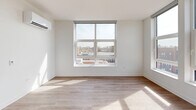 Located at 4733 North Wolcott Avenue in Chicago's Ravenswood neighborhood, this thoughtfully designed 2-bedroom, 2-bathroom unit offers a clean, contemporary aesthetic with light wood-look flooring and crisp white walls throughout. The open-concept kitchen and living area serves as the heart of the unit, featuring a large center island with white quartz countertops, stainless steel appliances including a gas range, microwave, and French door refrigerator, white upper cabinetry paired with warm wood-toned lower cabinets, and stylish pendant lighting. Oversized windows in both the kitchen and living areas flood the space with natural light and offer open views of the surrounding Chicago cityscape. Both bedrooms are well-proportioned, with large windows that bring in ample daylight and urban views. The primary bedroom includes a dedicated closet with built-in wire shelving, and the unit features a total of three closets for generous storage. The two bathrooms are finished with white vanities, quartz countertops, and LED-lit mirrors, maintaining the unit's clean modern palette. A dedicated in-unit laundry closet houses a stacked Electrolux washer and dryer. A central hallway connects all rooms efficiently, completing this well-appointed Chicago residence.