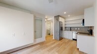 Located at 2009 North Howard Street in Philadelphia, PA, this thoughtfully designed one-bedroom, one-bathroom unit offers a clean, modern aesthetic across a single floor. Light hardwood flooring flows seamlessly throughout the living spaces, complementing the bright white walls and contemporary finishes.

The open kitchen is efficiently arranged with white flat-front cabinetry, open shelving, a textured tile backsplash, and a full suite of stainless steel appliances including a refrigerator, electric range, microwave, and dishwasher. A sleek sink with a matte black faucet anchors the layout.

The bedroom is a calm, light-filled retreat featuring dual windows with roller shades, a ceiling fan, and a wall-mounted mini-split unit for climate control. Natural light fills the room, creating a serene atmosphere.

The bathroom features a white vanity with an integrated sink, a lighted mirror, and large-format tile flooring. A frosted glass sliding door adds a modern touch to the living area entry.

The hallway connects all rooms efficiently and includes a built-in stacked washer and dryer — a practical in-unit convenience. Recessed lighting and a neutral palette throughout give the space a polished, move-in-ready feel.